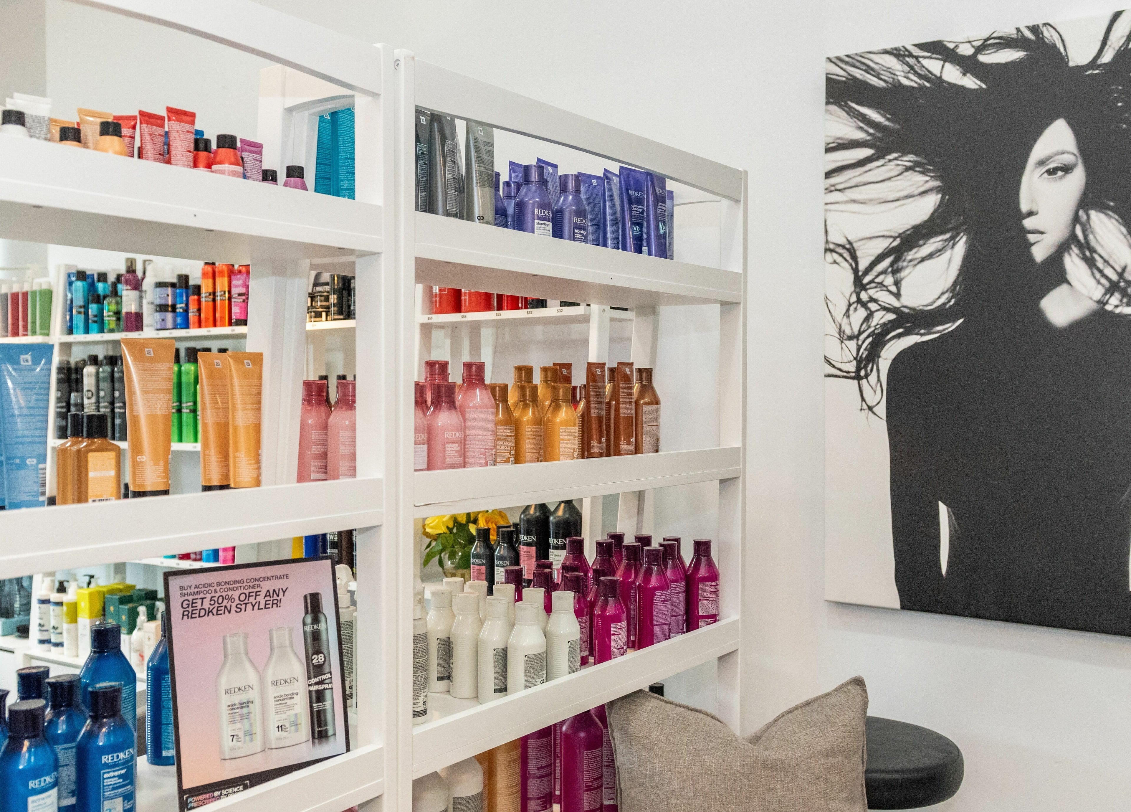 Product shelves and stylish art at Moochini Hair Salon in Alpharetta, Georgia, US enhance the salon's ambiance.