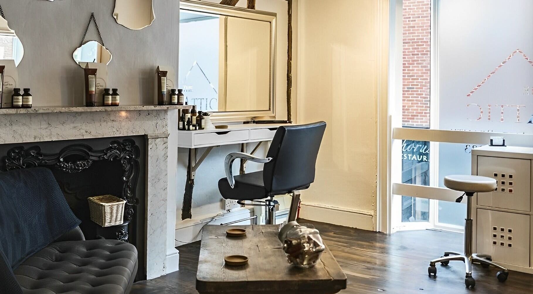 Elegant salon interior at Attic Hair & Beauty, Hitchin, England, GB, featuring a modern styling chair and mirrors.