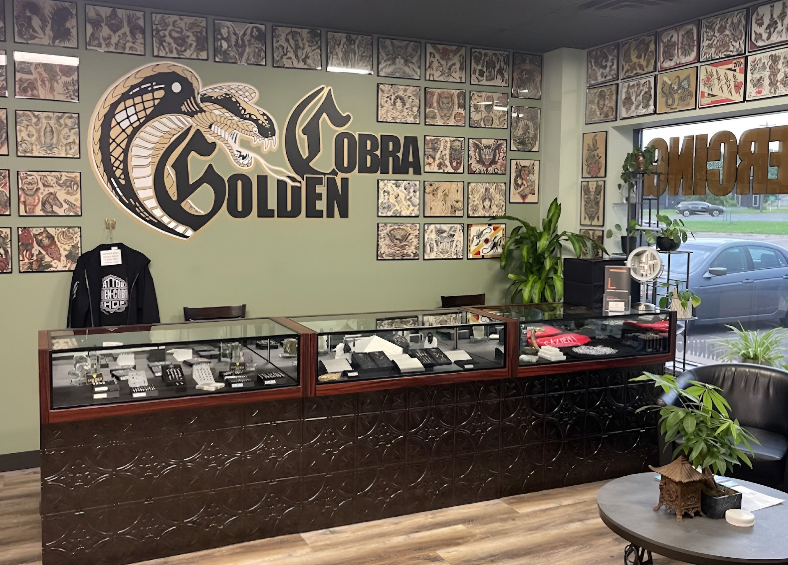 Interior of Golden Cobra Tattoo and Piercing in Fridley, Minnesota, US featuring tattoo art and cozy seating.