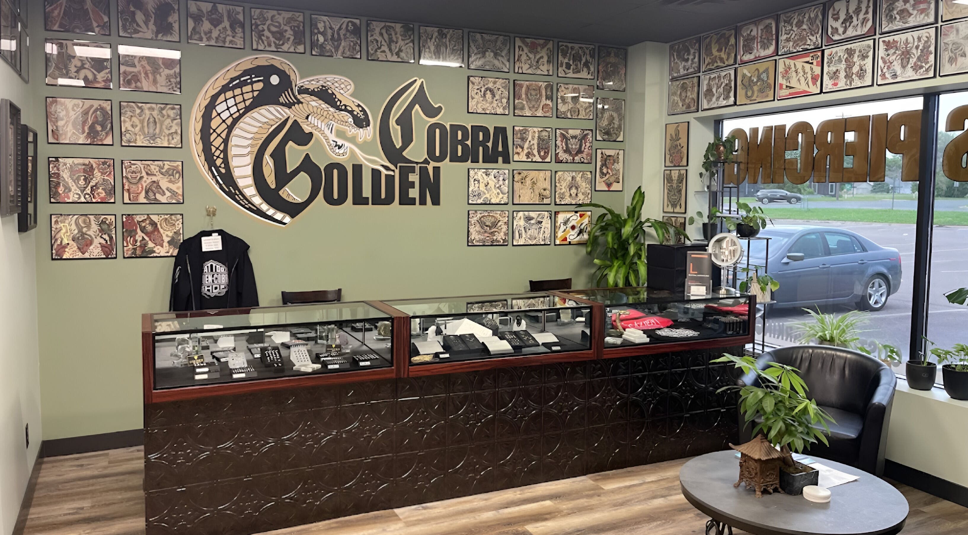 Interior of Golden Cobra Tattoo and Piercing in Fridley, Minnesota, US featuring tattoo art and cozy seating.