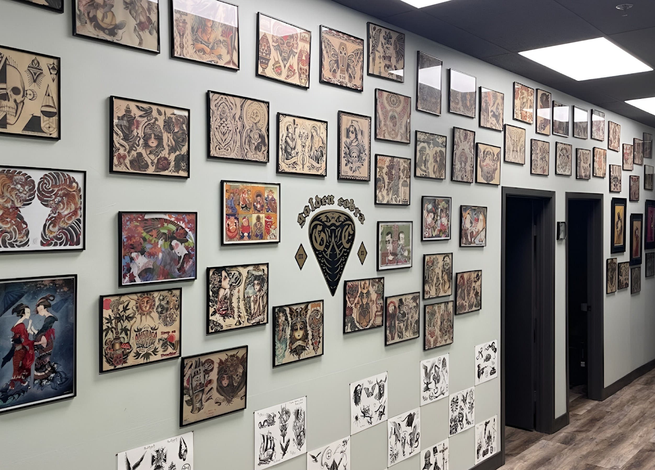 Wall of tattoo art at Golden Cobra Tattoo and Piercing, Fridley, Minnesota, US, showcasing diverse designs.