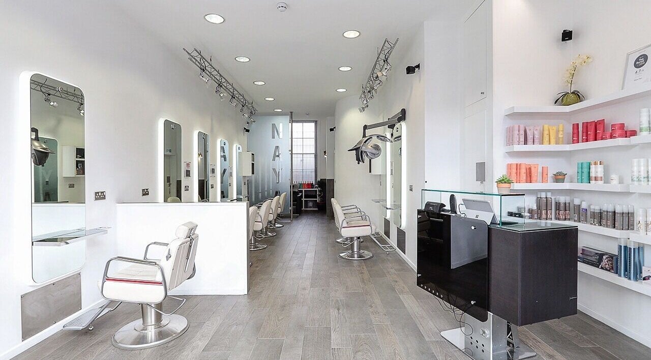 Chic interior of Naya Hair & Beauty in London, England, GB featuring sleek styling stations and bright decor.