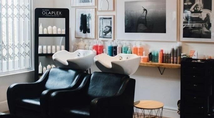 Stylish hair wash area at Gracie B Ltd, West Bridgford, England, GB with Olaplex products on display.