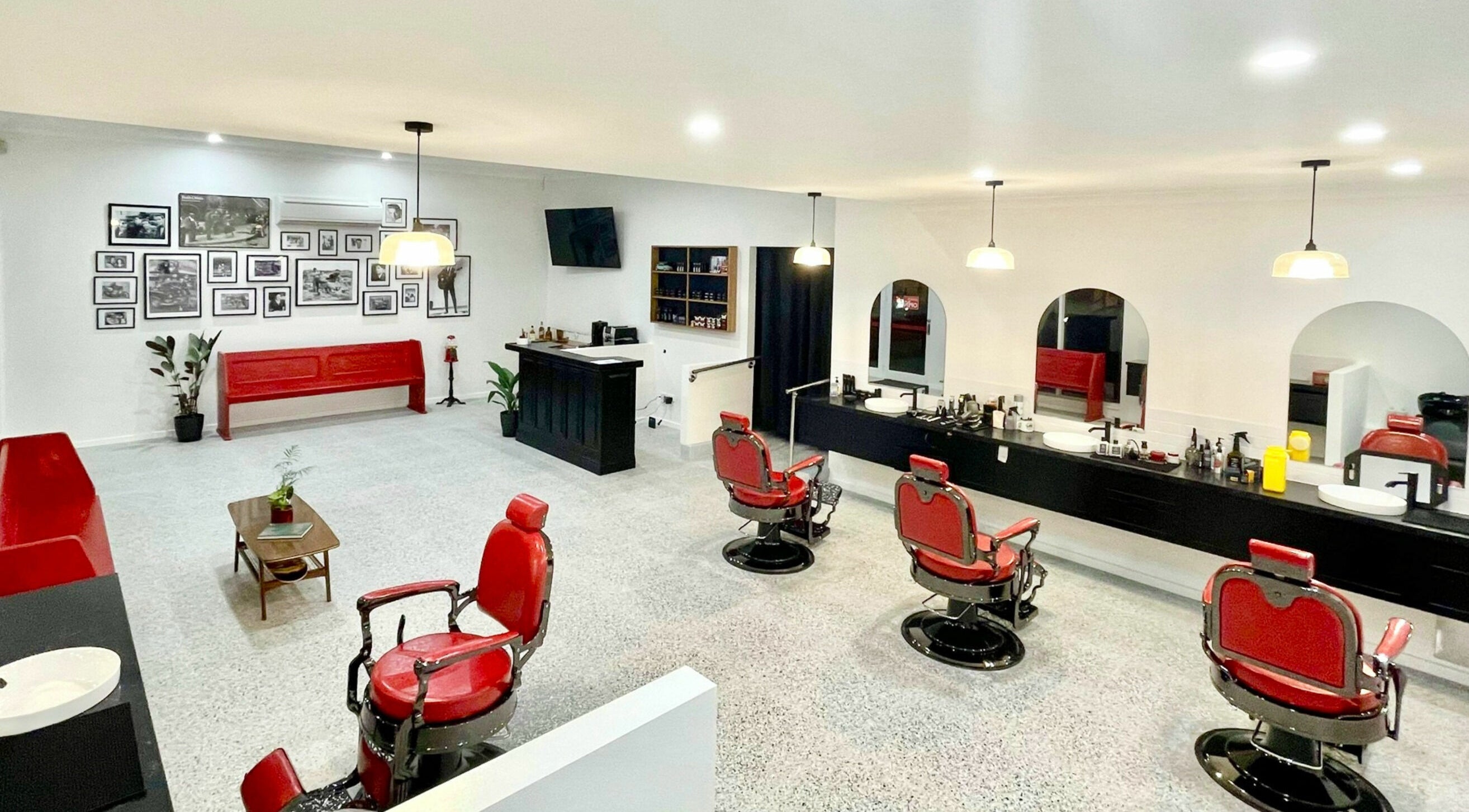 Classic interior of San Antonio Barbershop, Melbourne, Victoria, AU with vintage red chairs and stylish decor.