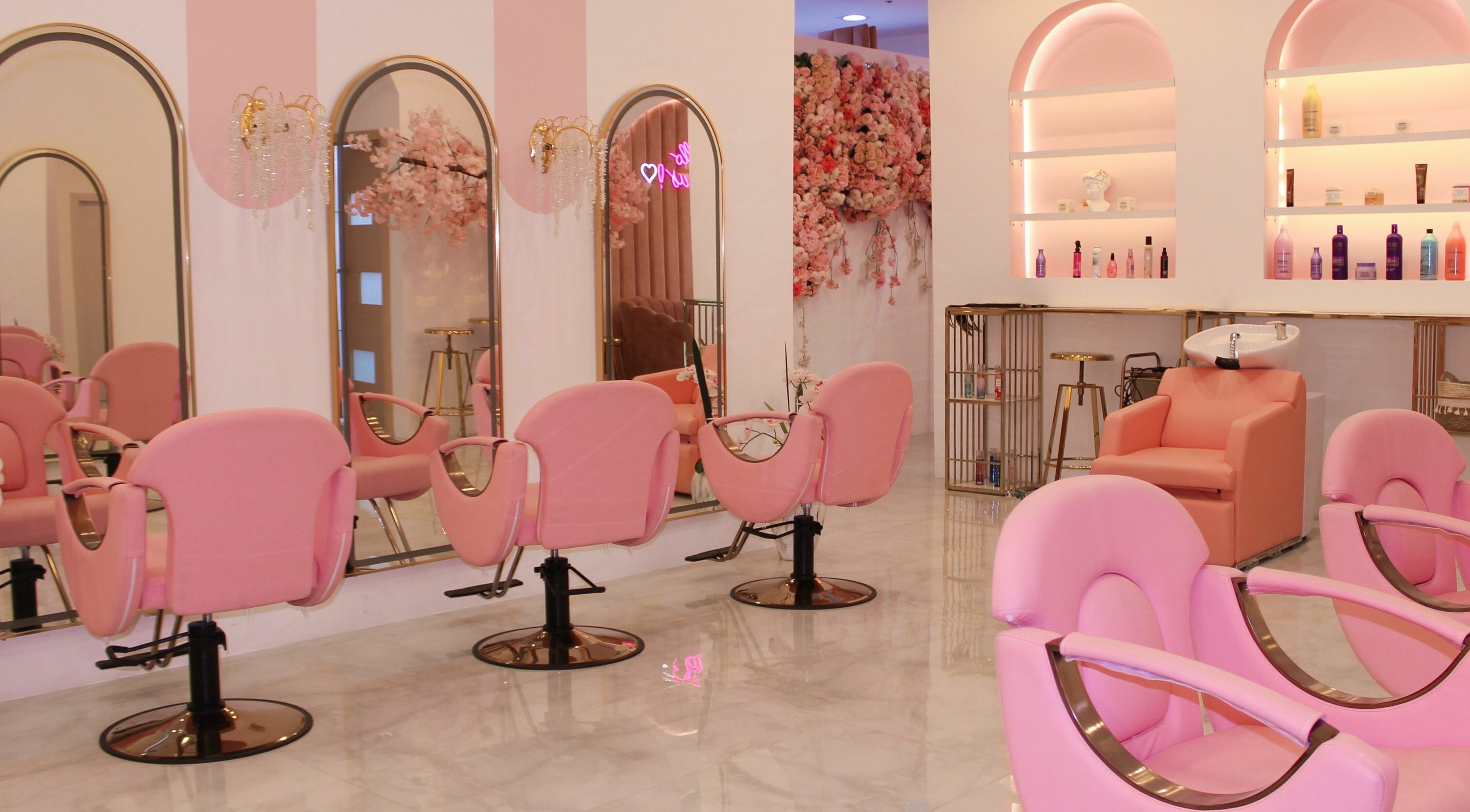 Elegant pink salon interior at Cerise Beauty Salon, Dubai, Dubai, AE, featuring stylish chairs and floral decor.