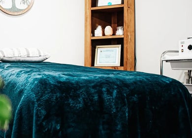 Cozy treatment room at Mountain Miracles Med Spa in Rangeley, Maine, US, featuring a plush teal bed.