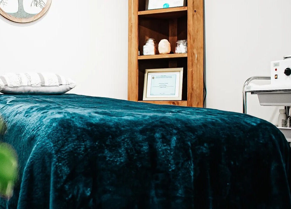 Cozy treatment room at Mountain Miracles Med Spa in Rangeley, Maine, US, featuring a plush teal bed.