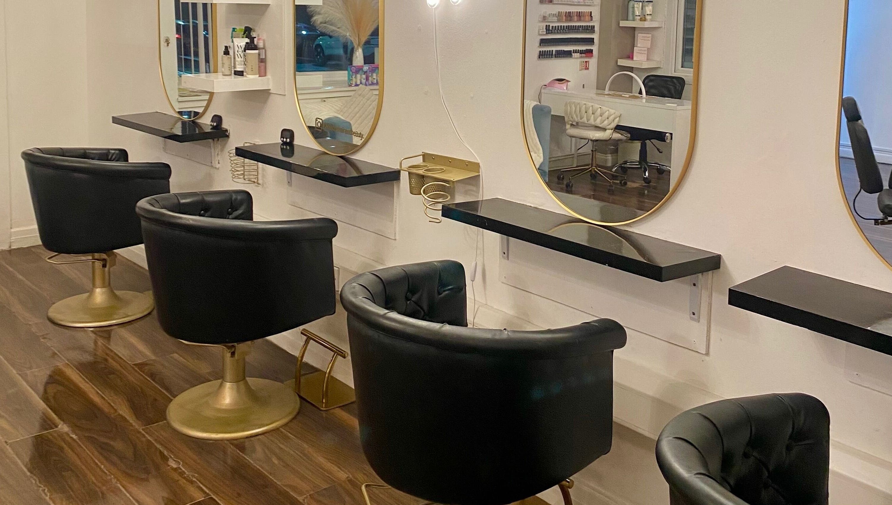Luxury hair stations at Blossom Hair & Beauty, Dumbarton, Scotland, GB, featuring black chairs and gold accents.