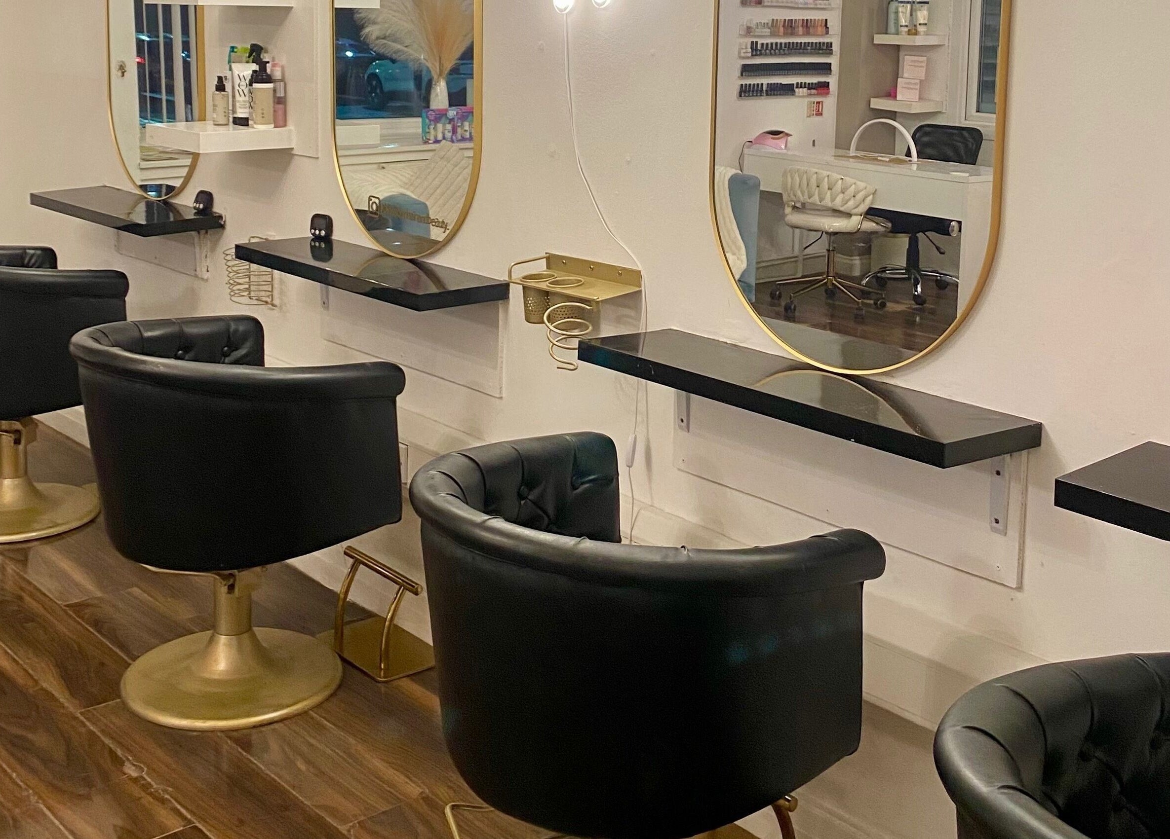 Luxury hair stations at Blossom Hair & Beauty, Dumbarton, Scotland, GB, featuring black chairs and gold accents.