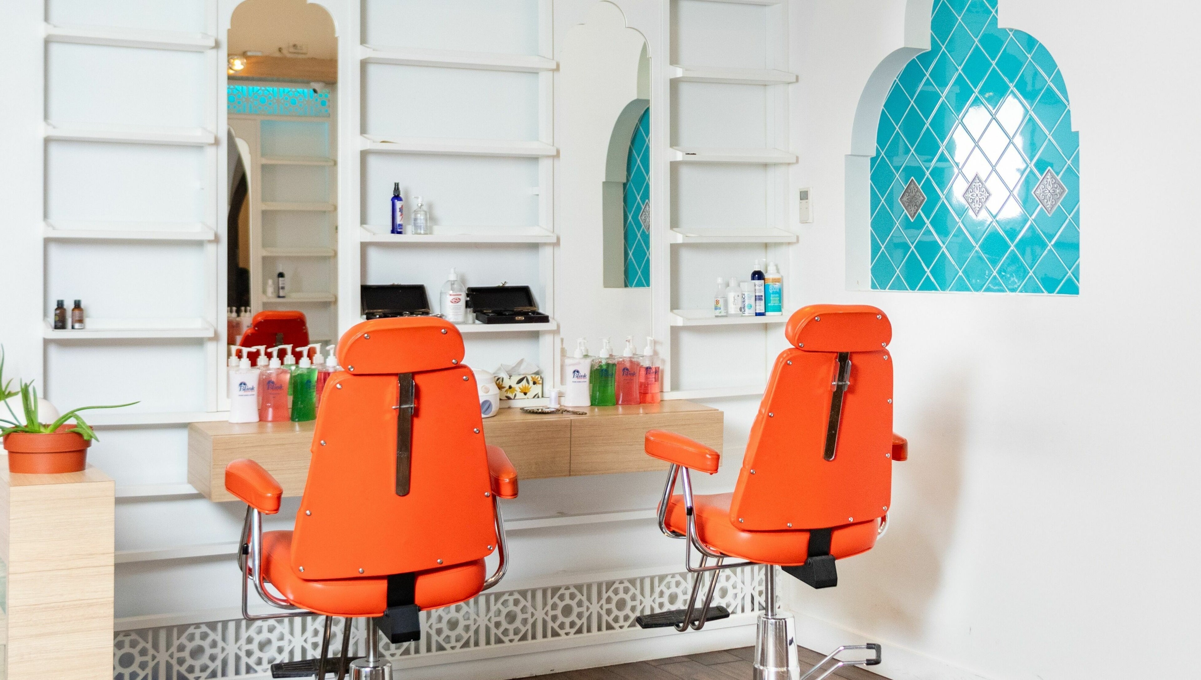 Bright orange chairs in modern interior of Blink Brow Bar, Vancouver, British Columbia, CA.