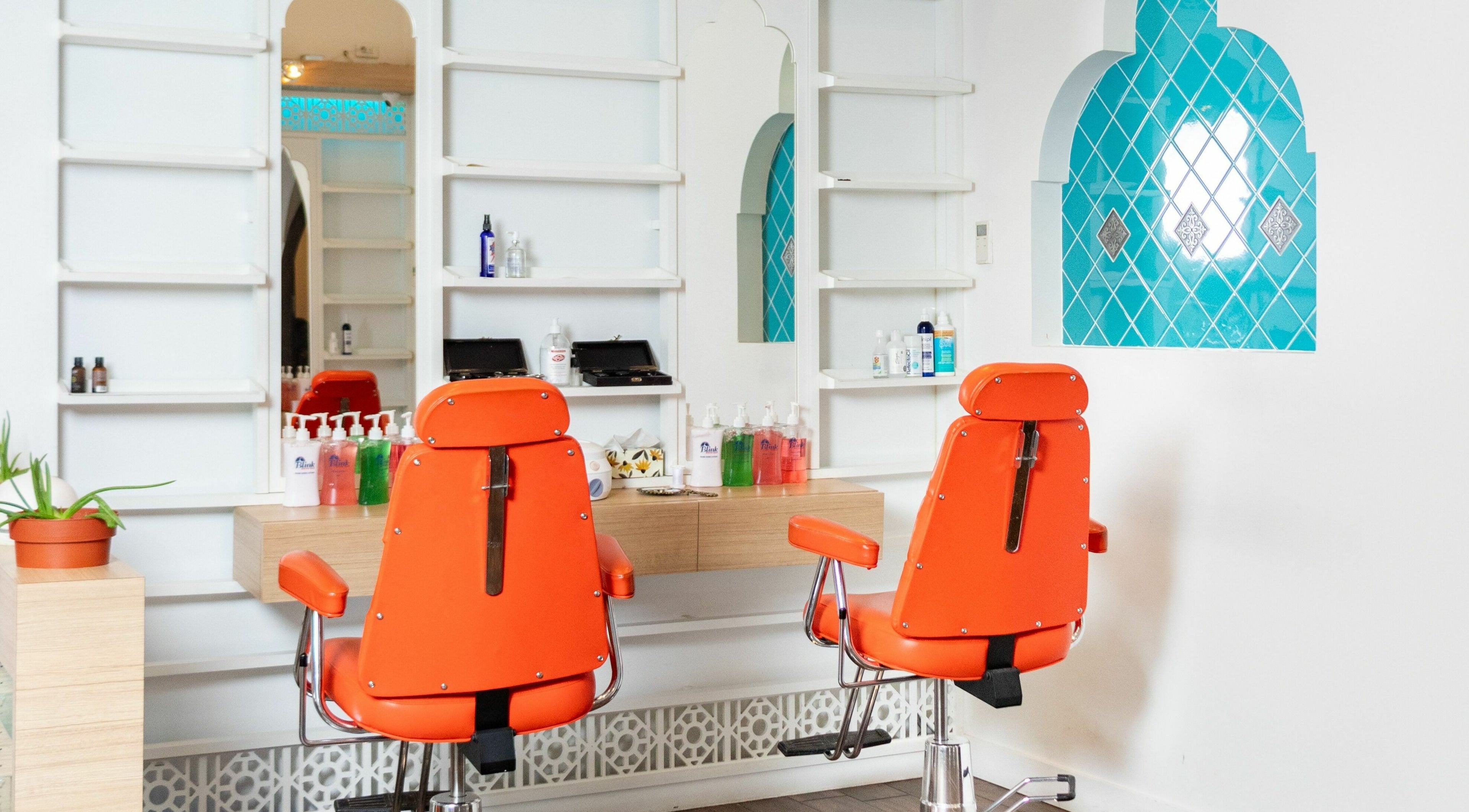 Bright orange chairs in modern interior of Blink Brow Bar, Vancouver, British Columbia, CA.
