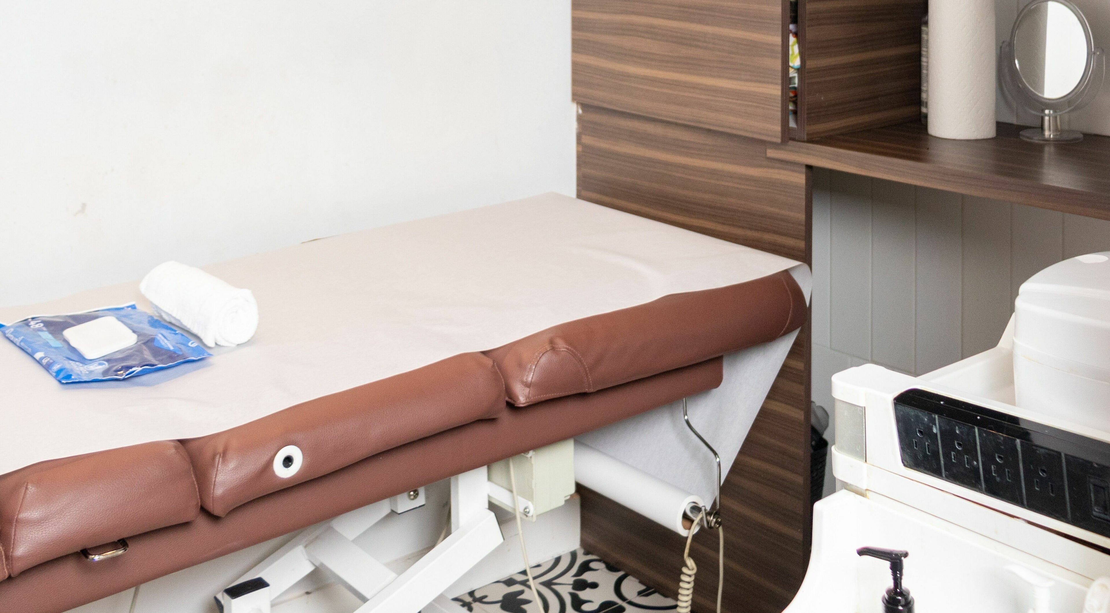 Cozy spa treatment room at Blink Brow Bar, Vancouver, British Columbia, CA, featuring a brown massage table.