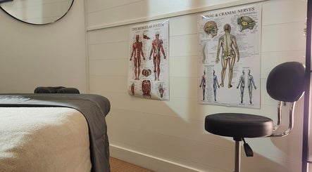 Salle de massage avec affiches anatomiques chez Propulsion Sportive, Blainville, Québec, CA.
