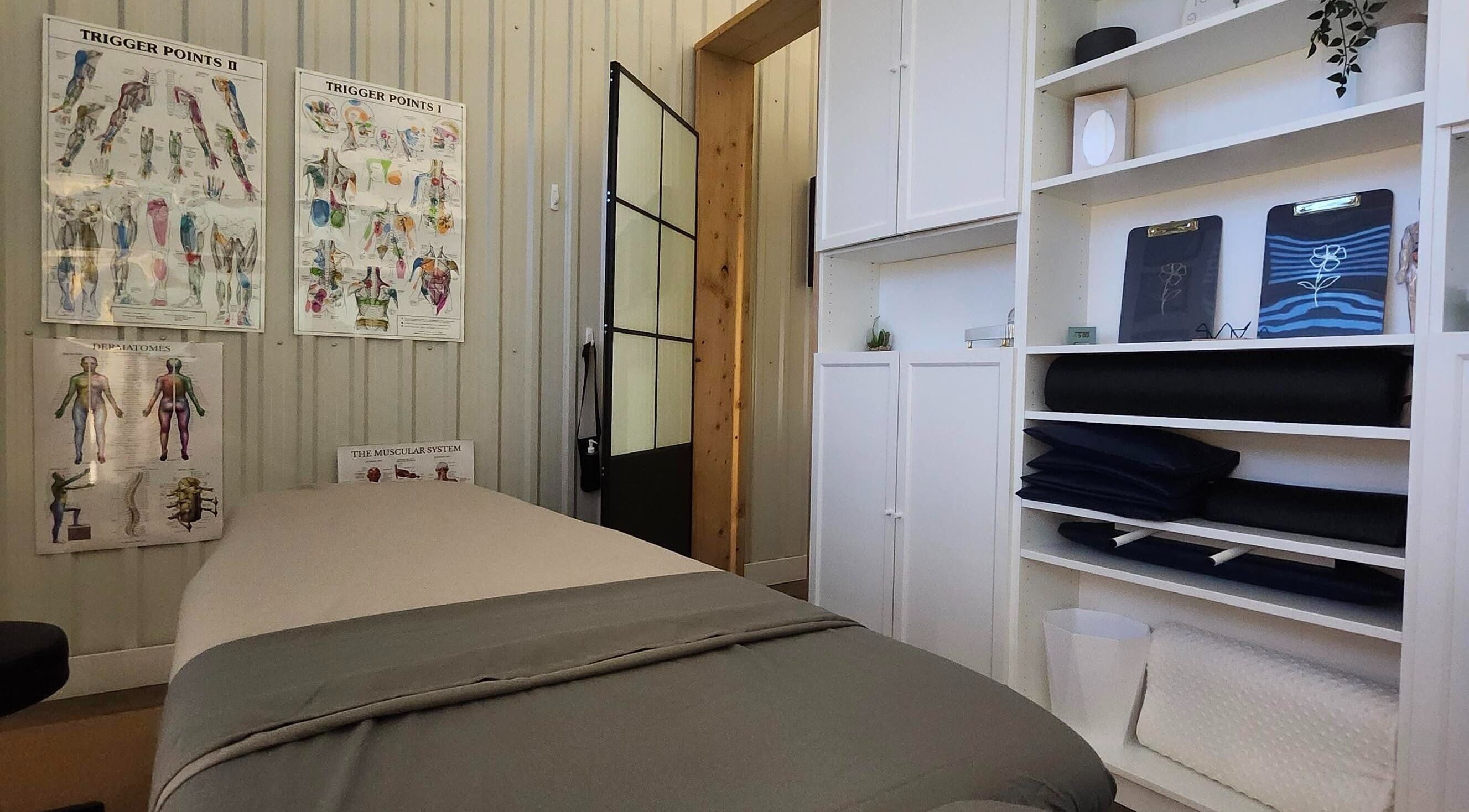 Salle de massage à Propulsion Sportive, Blainville, Québec, CA avec table de traitement et affiches anatomiques.