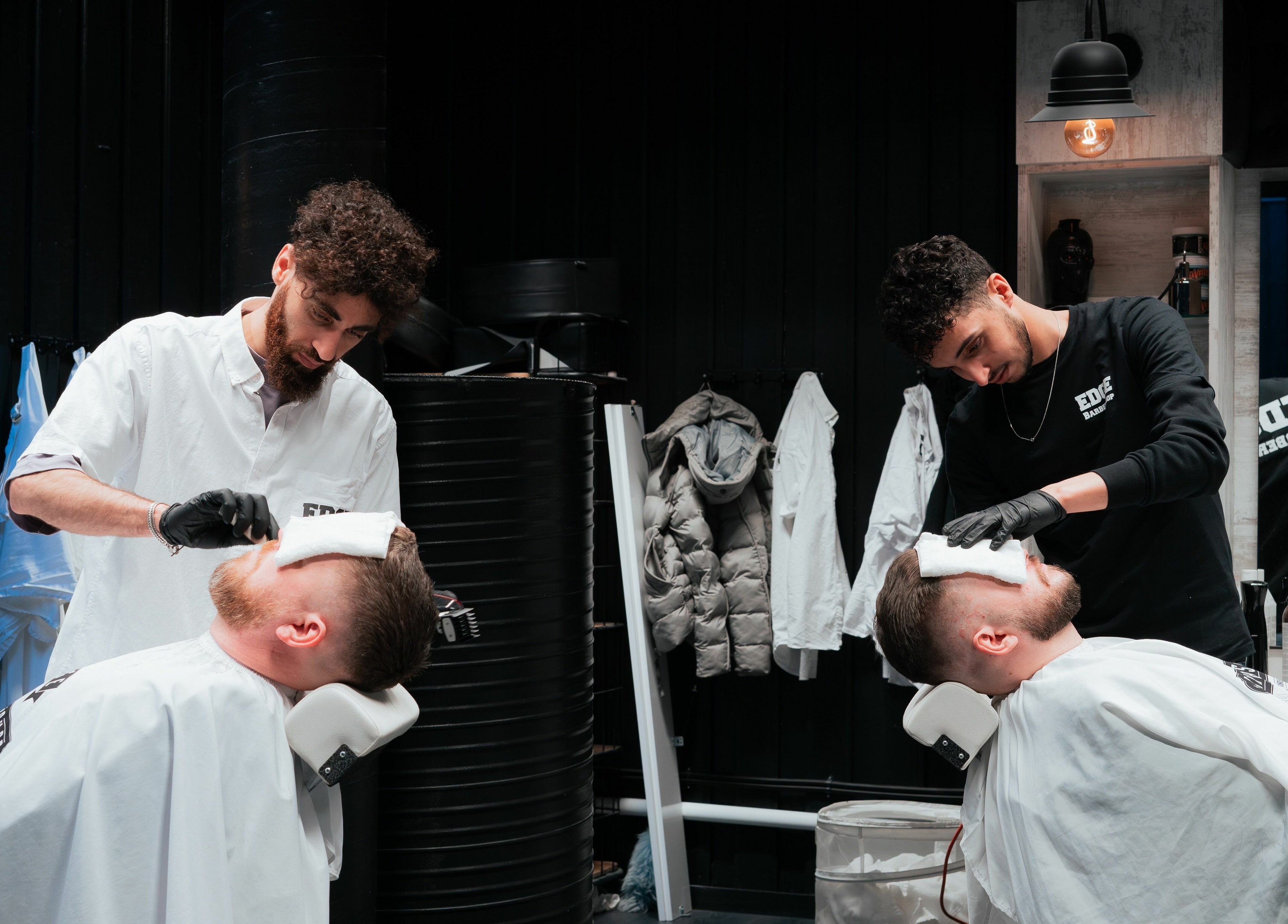 Barberer på Edge Barbershop Trondheim gir behandling til to kunder i Trondheim, Trøndelag, NO.