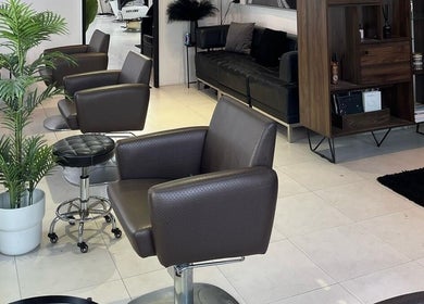 Elegant interior of RASL: Refined Artisan Salon Lounge, Singapore, SG, featuring modern chairs and greenery.