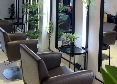 Spacious interior of RASL: Refined Artisan Salon Lounge in Singapore, SG, featuring elegant salon chairs and mirrors.