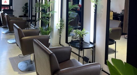 Spacious interior of RASL: Refined Artisan Salon Lounge in Singapore, SG, featuring elegant salon chairs and mirrors.