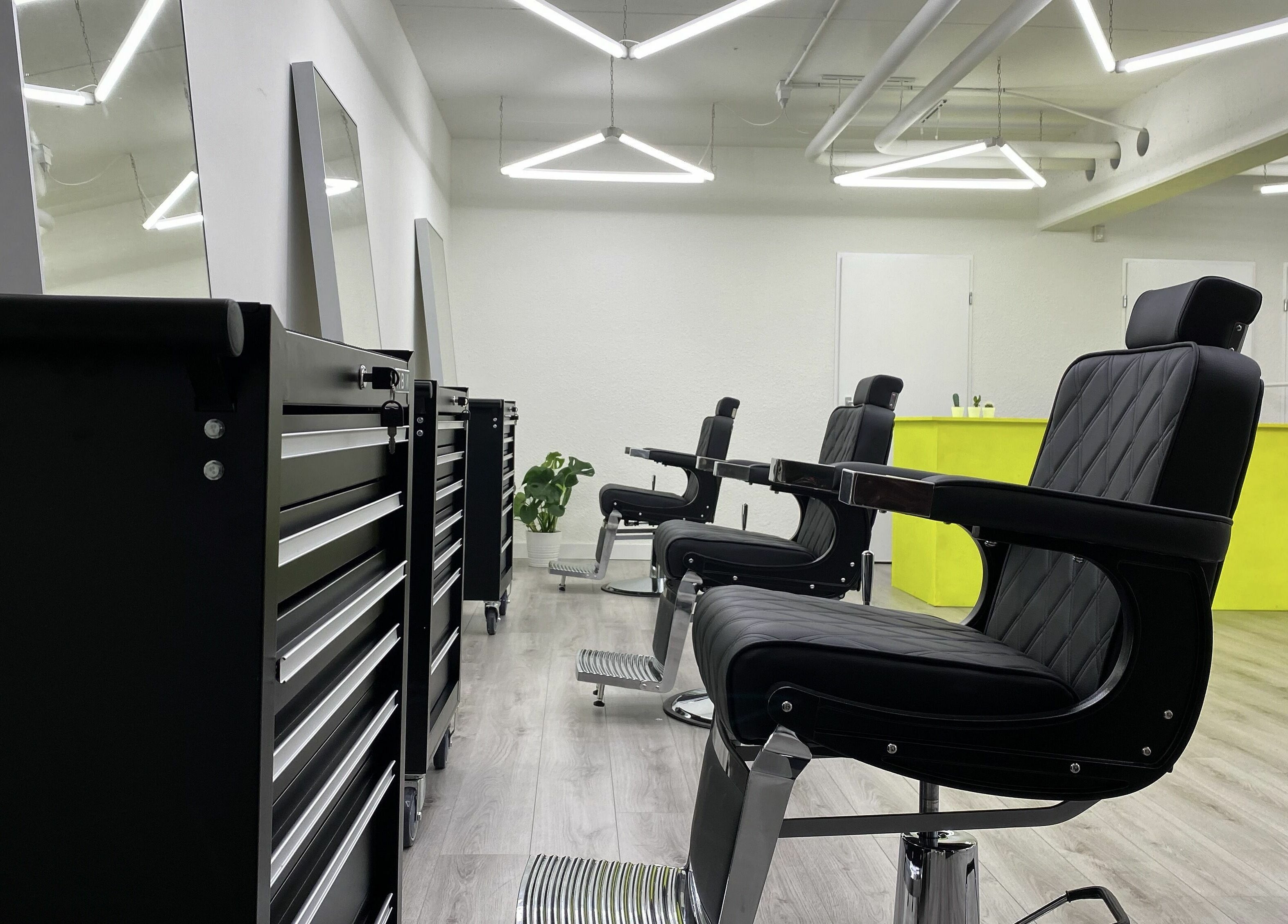 Stylish interior of Daily Grind Barbershop in Rotterdam, Zuid-Holland, NL with sleek chairs and bright decor.