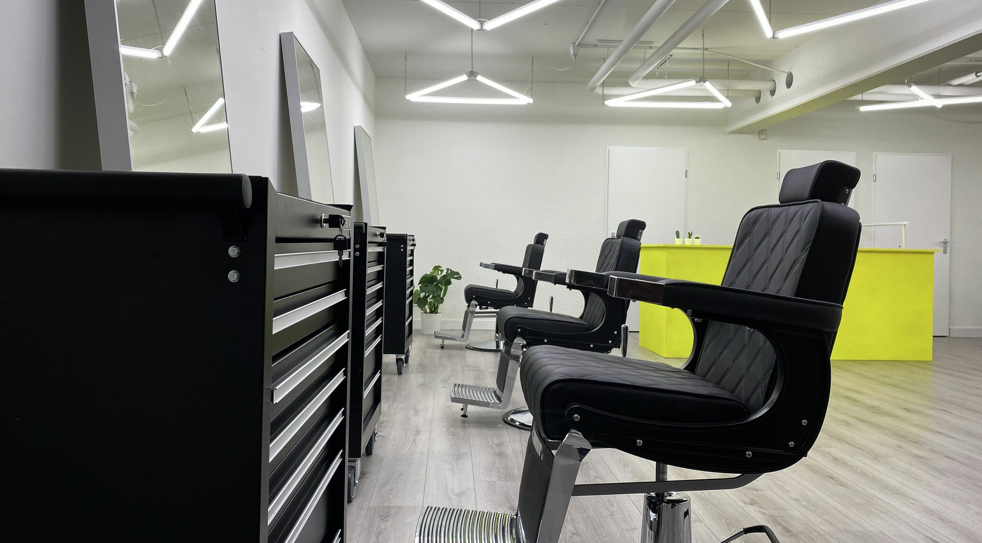 Stylish interior of Daily Grind Barbershop in Rotterdam, Zuid-Holland, NL with sleek chairs and bright decor.