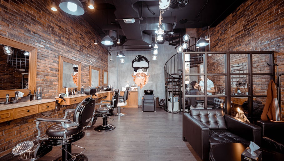 Interior of The Stars Barber Dubai, AE, featuring modern chairs, stylish brick walls, and ambient lighting.