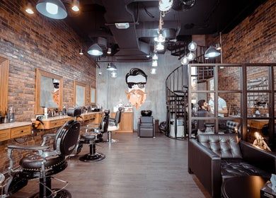 Interior of The Stars Barber Dubai, AE, featuring modern chairs, stylish brick walls, and ambient lighting.