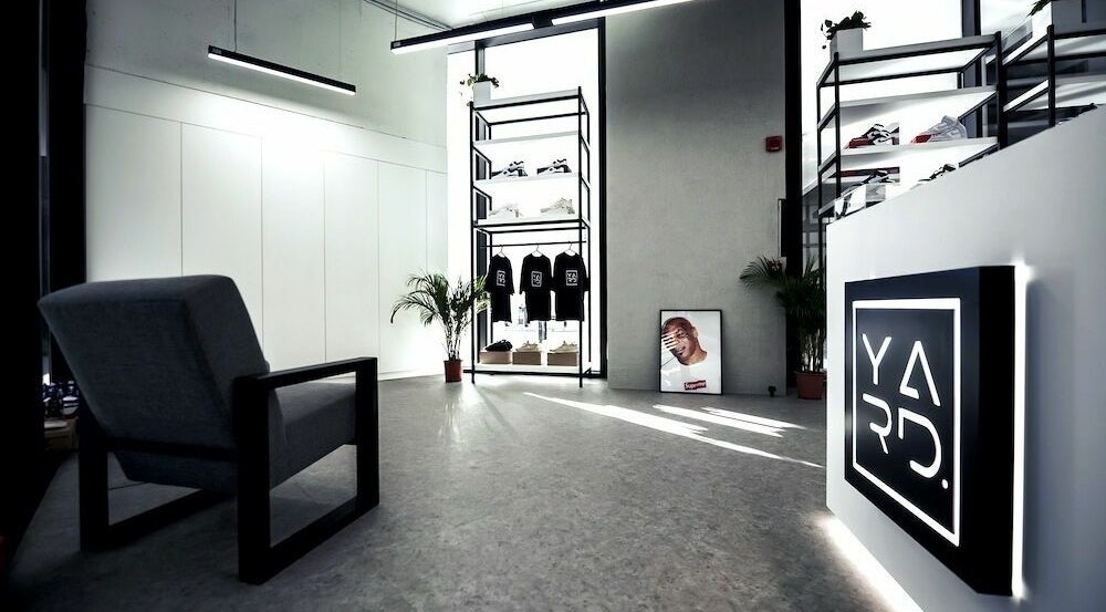Chic interior of YARD Barber and Shop in Dubai, AE showcasing stylish decor and clothing display.