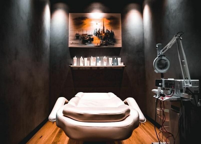 Elegant treatment room at Blade Craft, Dubai, Dubai, AE with a spa bed and skincare products on display.