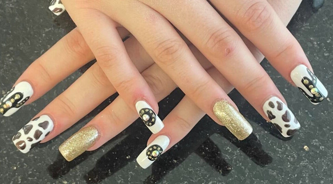 Stylish nail art at mkrnails&beauty academy in Kippax, England, GB featuring cow patterns and gold glitter.