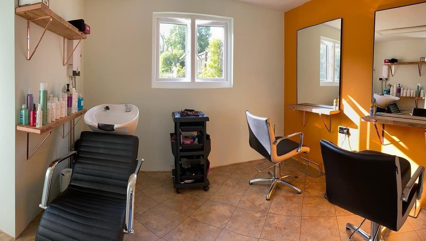 Bright salon space at Copper Cuts, Reading, England, GB with styling chairs and hair wash station.