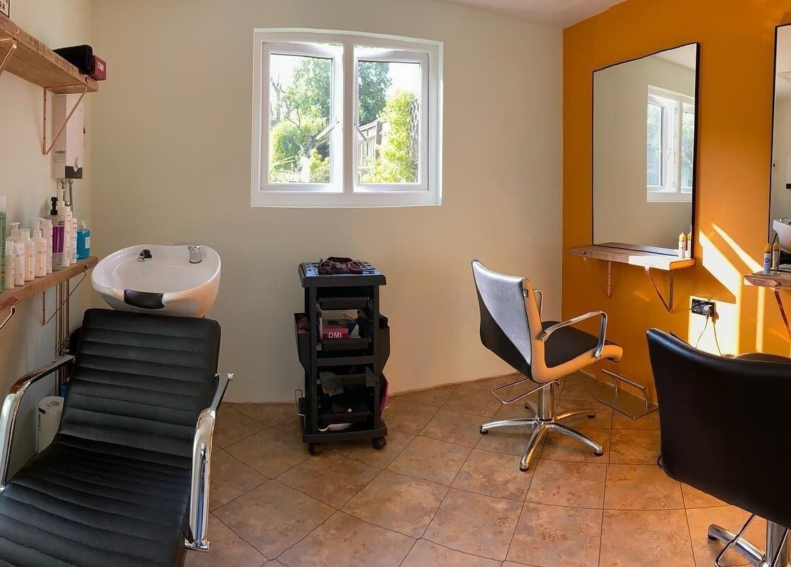 Bright salon space at Copper Cuts, Reading, England, GB with styling chairs and hair wash station.