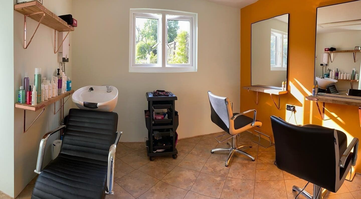 Bright salon space at Copper Cuts, Reading, England, GB with styling chairs and hair wash station.