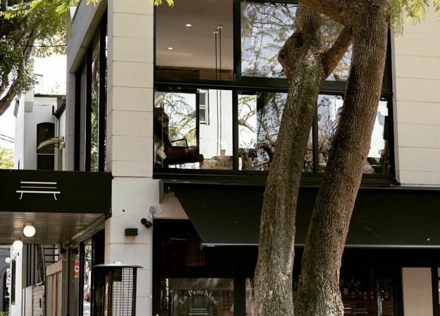 Exterior of Marc & Maxwell, a modern venue in Surry Hills, New South Wales, AU, surrounded by lush trees.