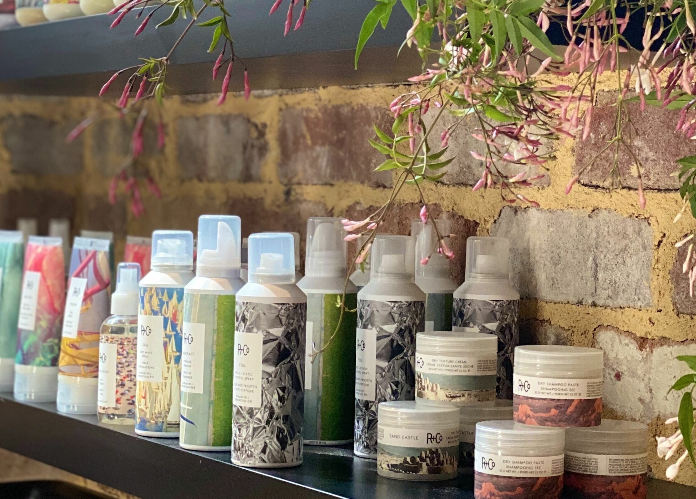 Beauty products on Marc & Maxwell shelf, Surry Hills, New South Wales, AU with blooming vines.
