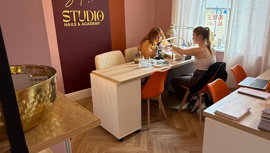 Cozy interior of Solo Studio in Amble, England, GB, featuring a nail service area with two clients.