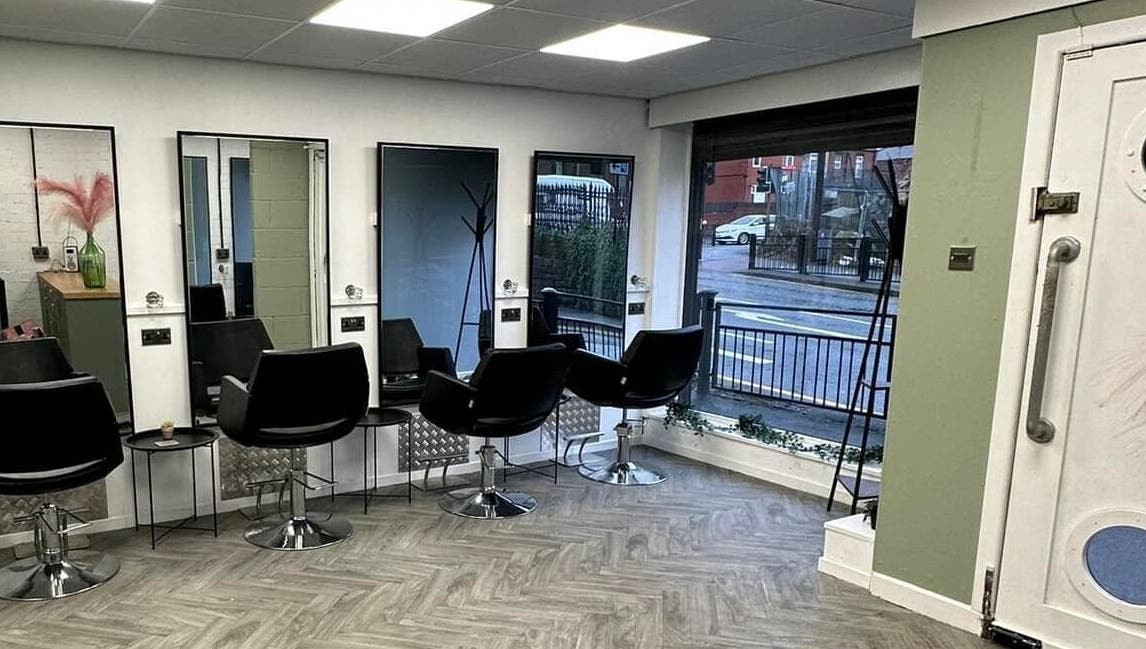 Modern salon chairs and mirrors inside Ivy Studio, Shaw, England, GB, offering a sleek and inviting atmosphere.