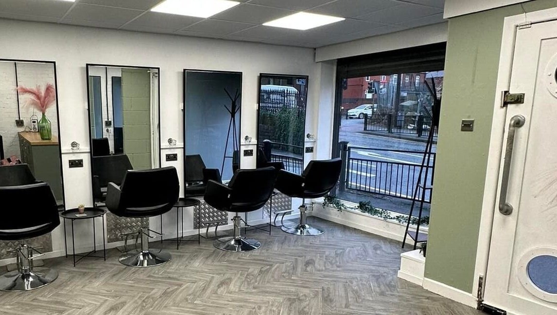 Modern salon chairs and mirrors inside Ivy Studio, Shaw, England, GB, offering a sleek and inviting atmosphere.