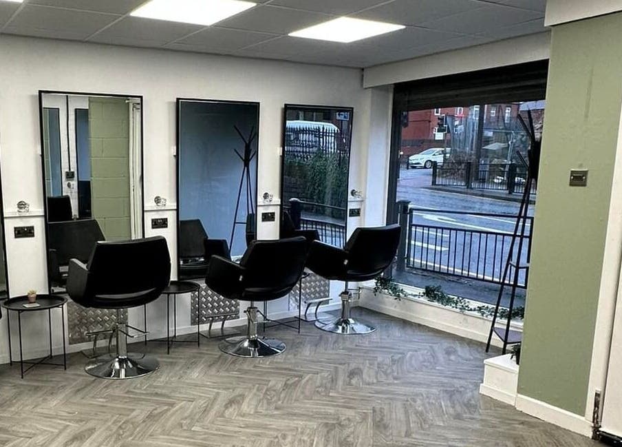 Modern salon chairs and mirrors inside Ivy Studio, Shaw, England, GB, offering a sleek and inviting atmosphere.