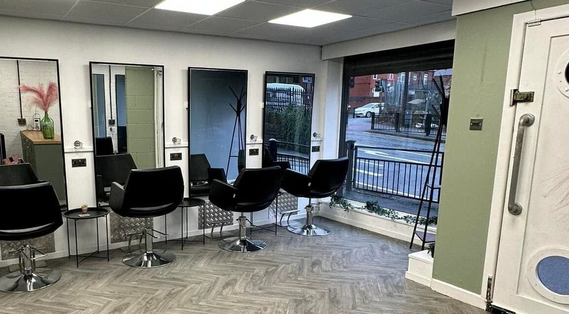 Modern salon chairs and mirrors inside Ivy Studio, Shaw, England, GB, offering a sleek and inviting atmosphere.