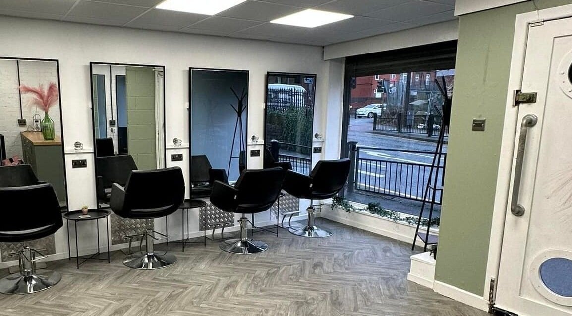 Modern salon chairs and mirrors inside Ivy Studio, Shaw, England, GB, offering a sleek and inviting atmosphere.