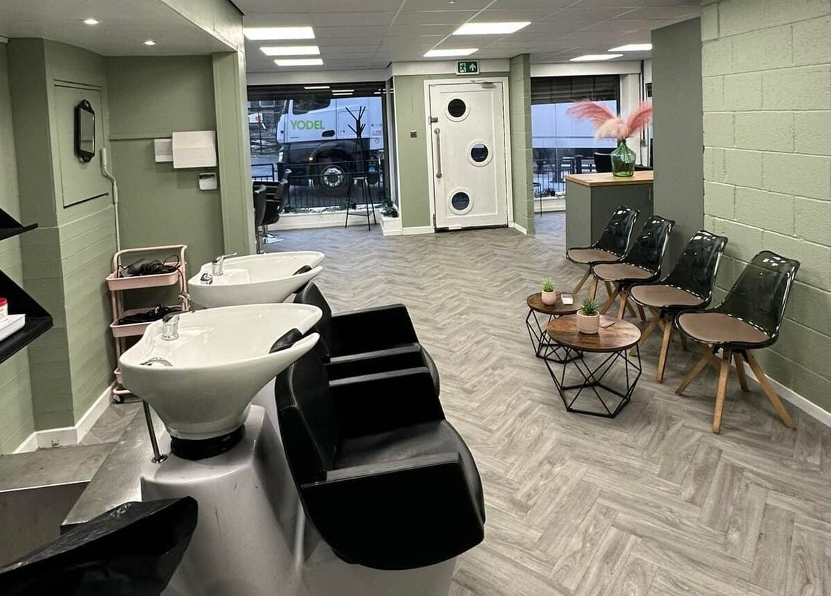 Modern salon interior at Ivy Studio in Shaw, England, GB, featuring stylish chairs and sleek washing stations.