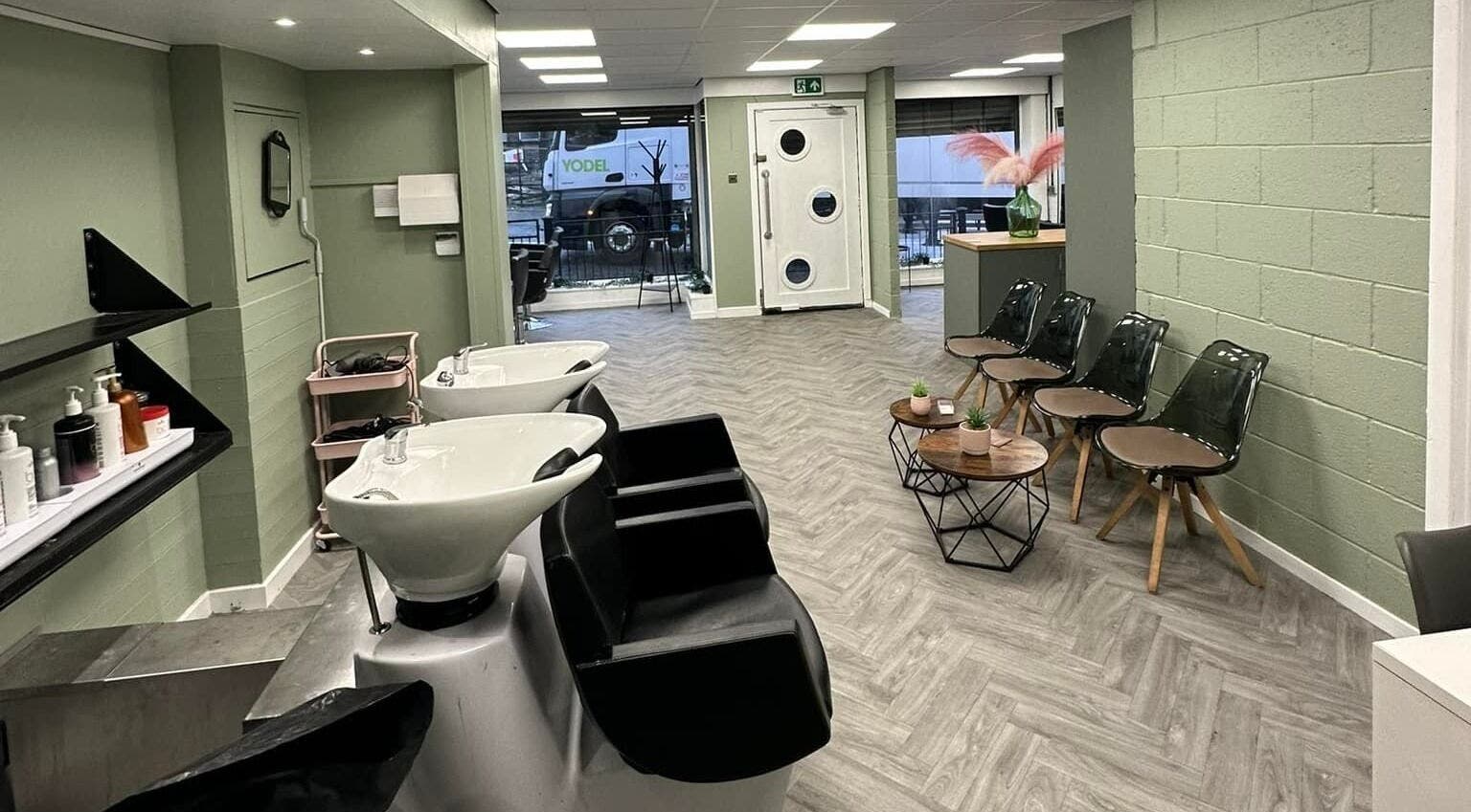 Modern salon interior at Ivy Studio in Shaw, England, GB, featuring stylish chairs and sleek washing stations.