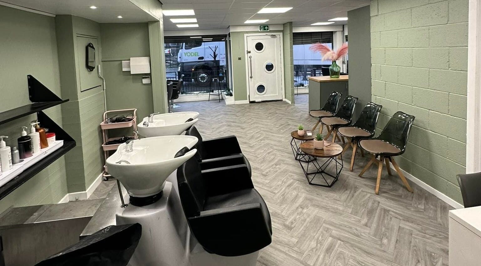 Modern salon interior at Ivy Studio in Shaw, England, GB, featuring stylish chairs and sleek washing stations.