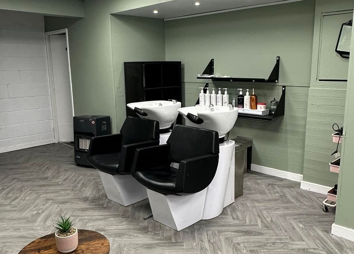 Modern shampoo stations at Ivy Studio, Shaw, England, GB. Elegant design with sleek chairs and product shelves.