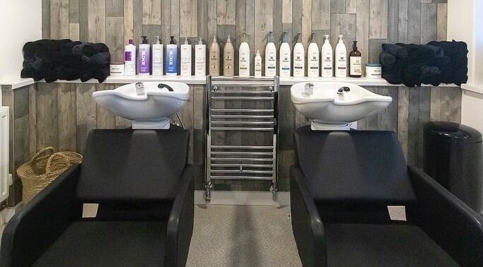 Chic hair wash stations at Blew St Ives, St Ives, England, GB with modern black chairs and premium products.