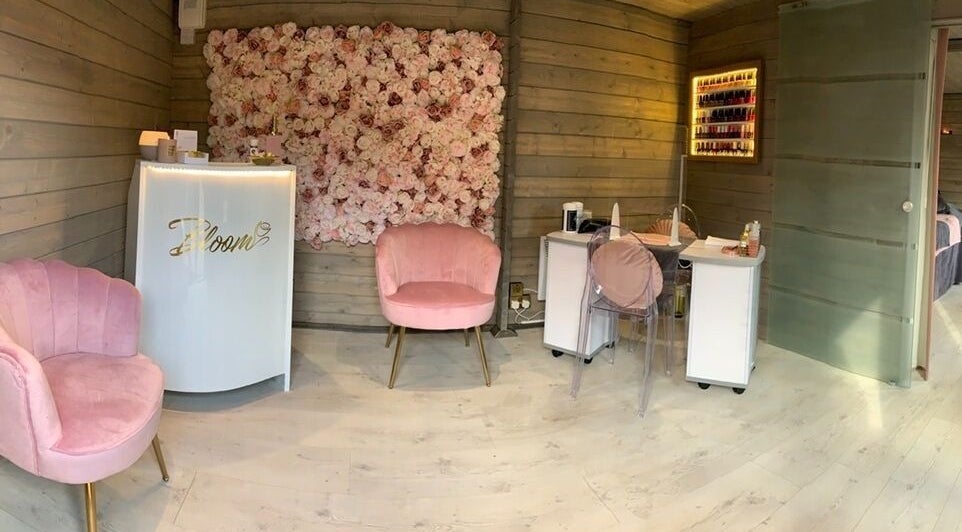 Chic interior of Bloom Beauty Studio with pink chairs and a floral wall in The Royal Town of Sutton Coldfield, England, GB.