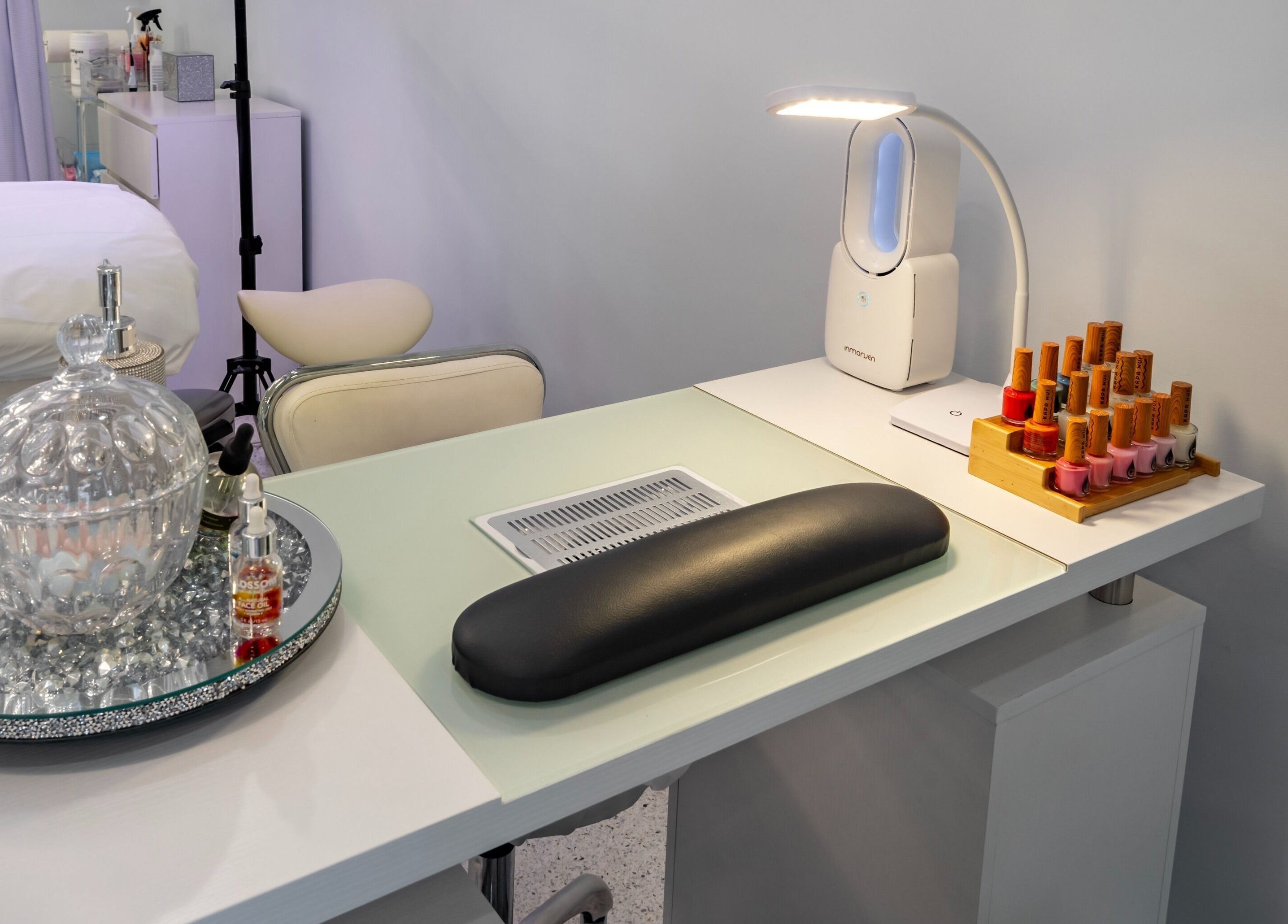 Elegant nail salon setup at By Pri, Vero Beach, Florida, US, featuring polish display and manicure lamp.