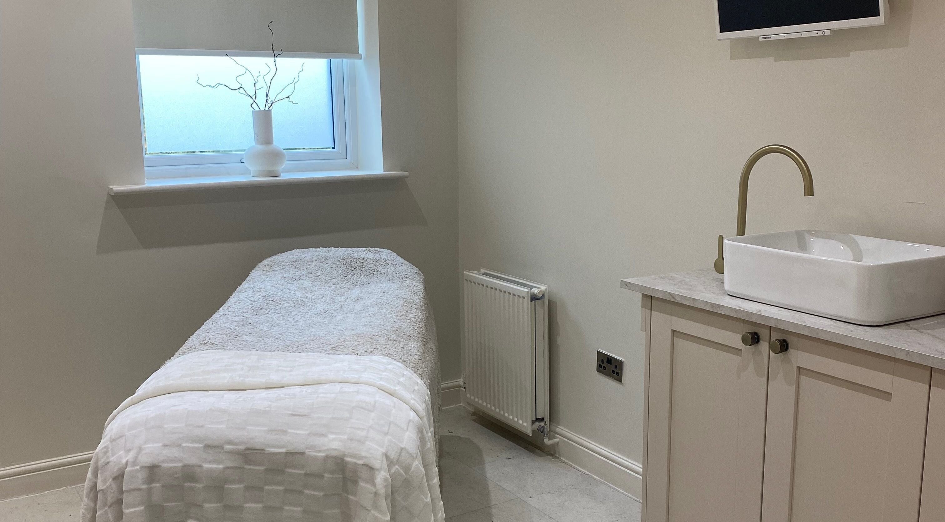 Serene treatment room at Atelier Hair & Beauty Studio in Bolton, England, GB, with a plush bed and stylish sink.
