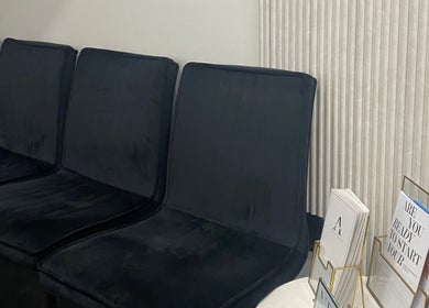 Comfortable black chairs in the waiting area at Atelier Hair & Beauty Studio in Bolton, England, GB.