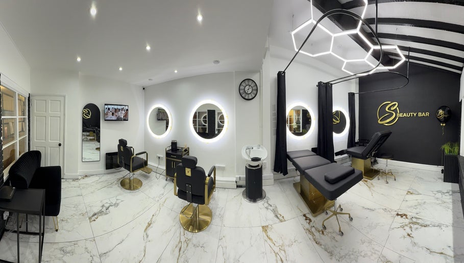 S Beauty Bar in Northampton, England, GB, features chic decor with modern salon chairs and illuminated circular mirrors.